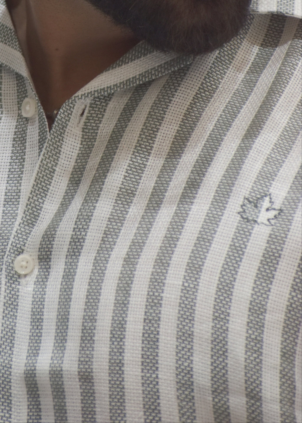 Man wearing a striped shirt with a neutral background