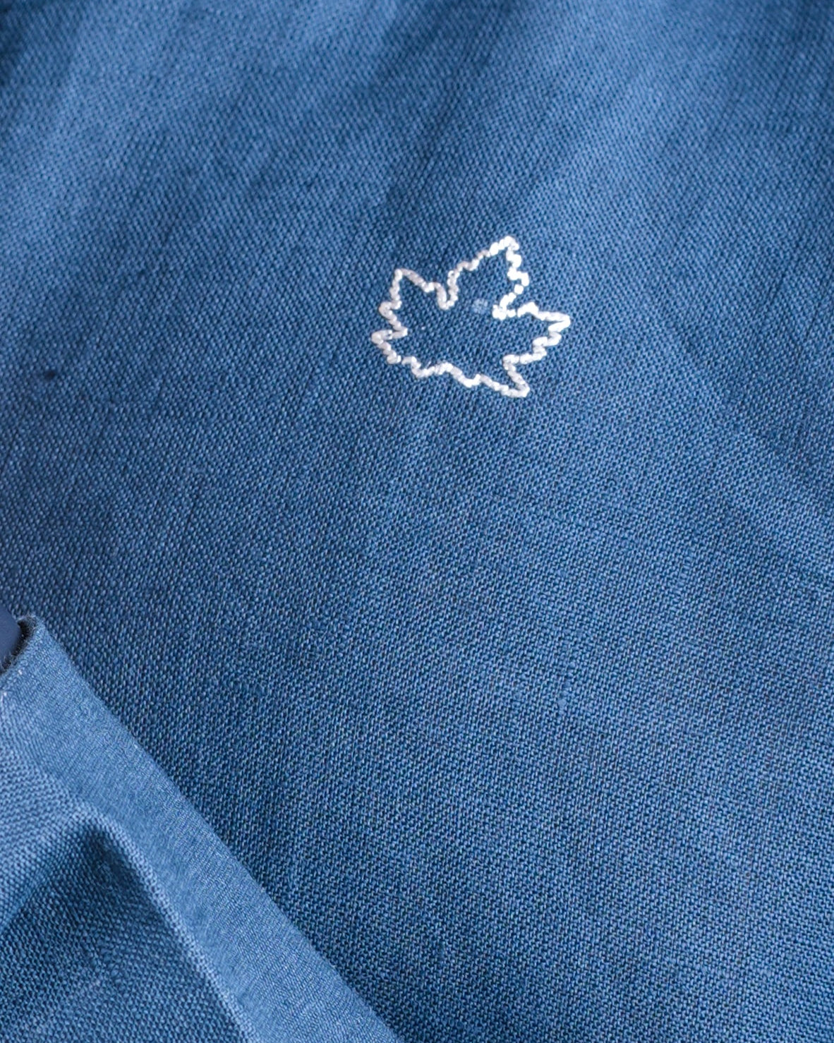 Blue fabric with a white maple leaf emblem